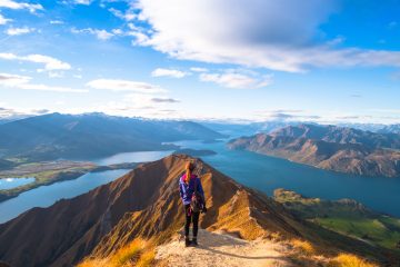 A hiker looking at the beautiful landscape of the mountains and Lake Wanaka. Roys Peak Track, South Island, New Zealand.